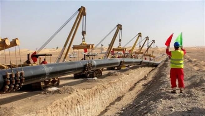 Pipeline being laid by a row of side-boom tractors